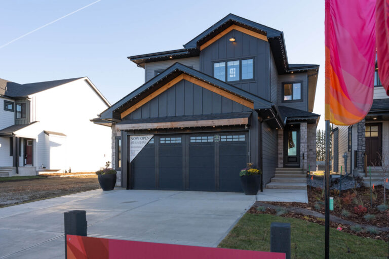 Two-story modern home with dark grey siding and warm wood exterior accents in Edmonton.