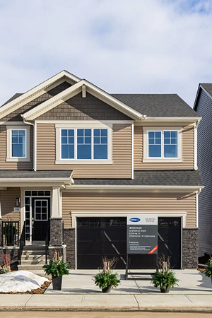 House with yellow siding and stone masonry exterior work by Edmonton siding and masonry contractors.