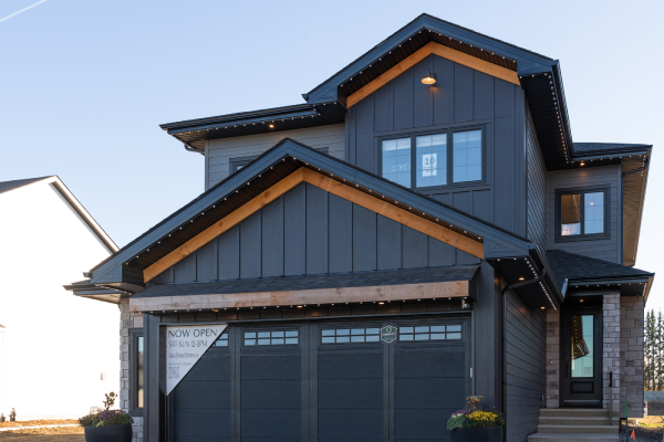 Residential home with dark grey siding and natural wood exterior accents by Edmonton siding contractors.