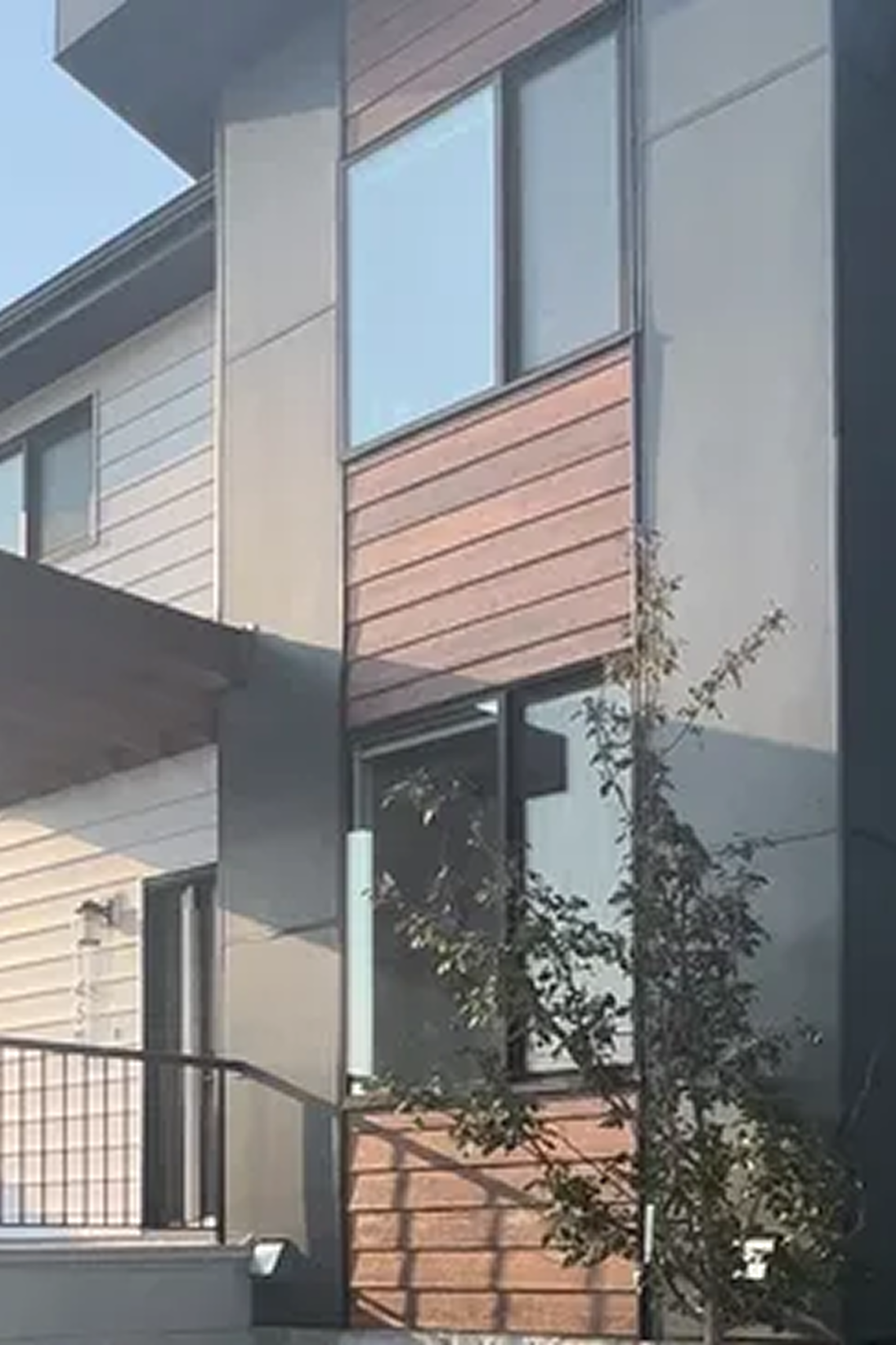 Modern building with black metal siding and wood accents installed by Edmonton exterior contractors.