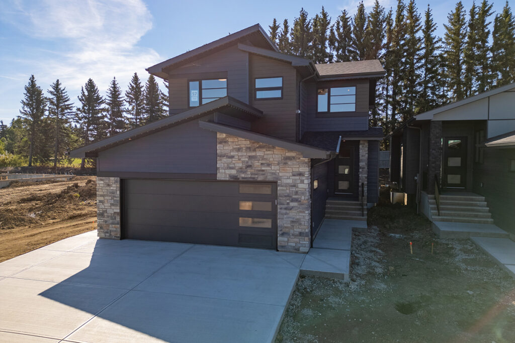 Modern home featuring expertly crafted stone masonry on the exterior facade and garage pillars, showcasing professional residential stonework.