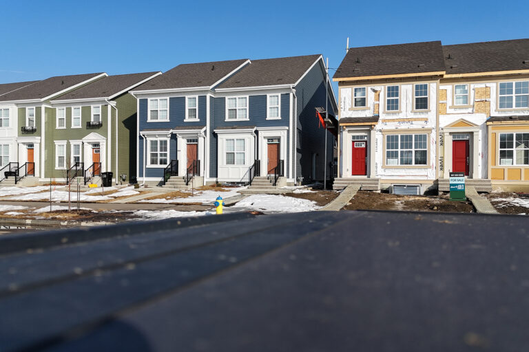 A row of multi-family houses sit in the bright light of sunrise. Great Canadian Exteriors is ready to help make your home a beautiful sight on the curb.